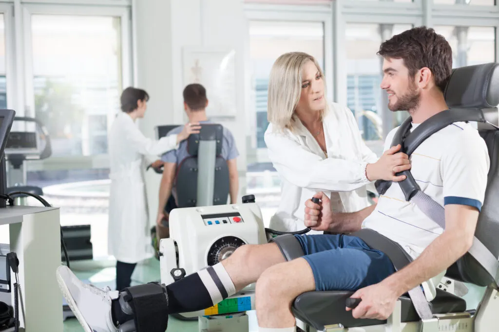 physicians with patients in a gym for physical rehabilitation dynamometer in the foreground and in the background cycle ergometer